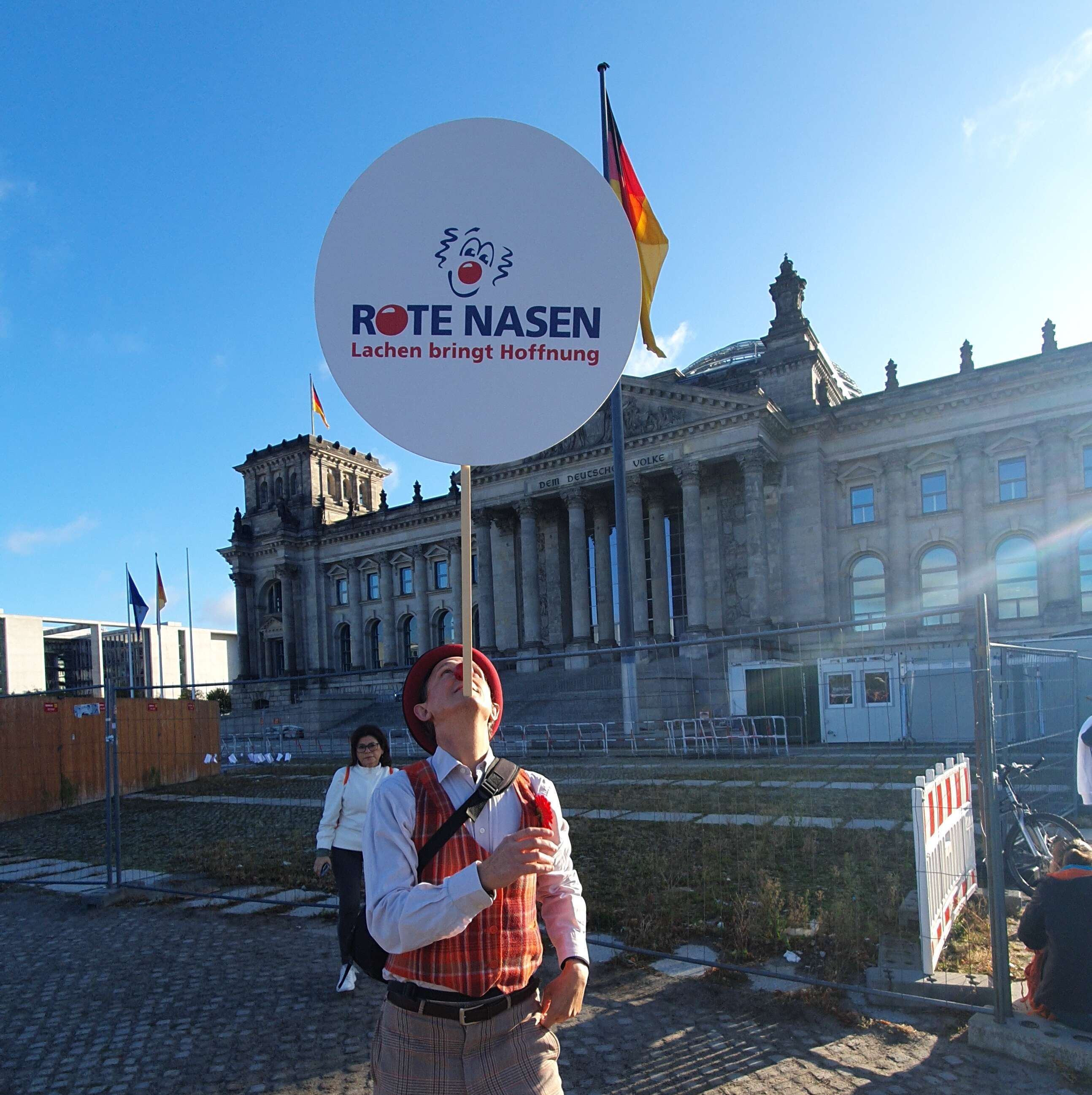 Clown Bartusch balanciert ein ROTE NASEN Schild auf seinem Kinn