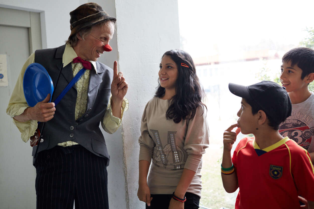 Ein Clown zeigt Kinderen in einer Flüchtling Einrichtung einer seiner Tricks 