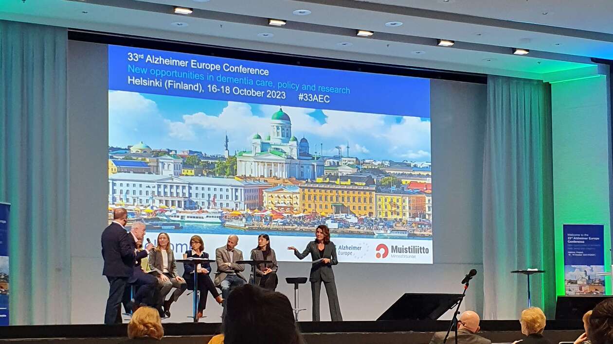 Konferenzsaal mit beleuchteter Leinwand.