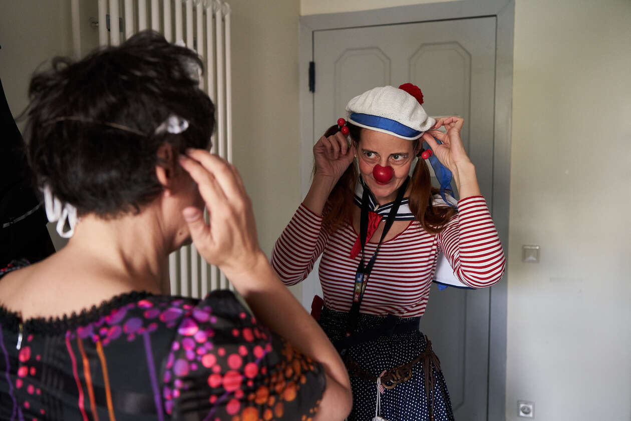 Zwei Clowns stehen sich gegenüber und halten sich die hände an ihre Ohren 