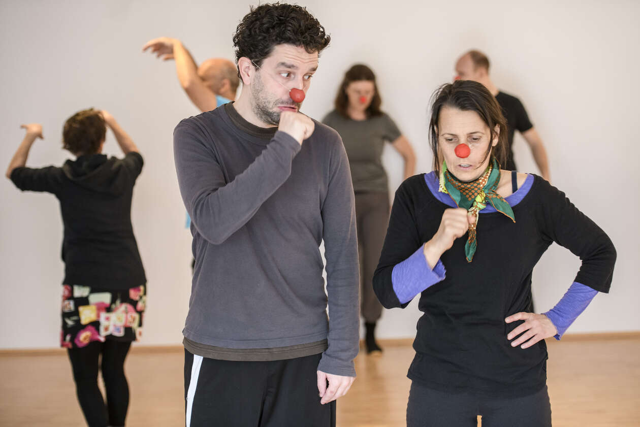 Clowns machen übungen für ihre stimmen und im hintergrund sieht man noch andere Künstler 