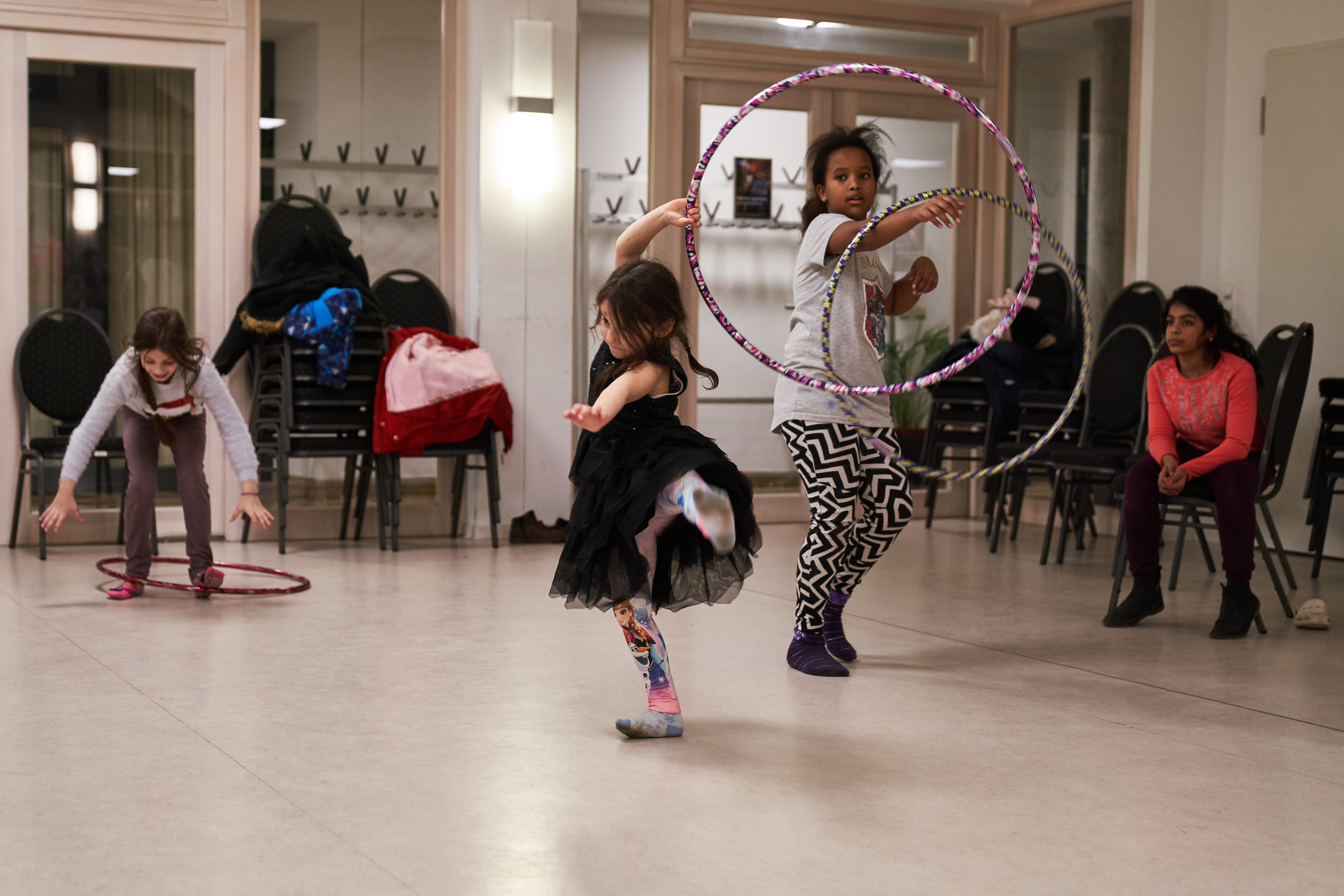 Zwei Mädchen tanzen mit eine Hullahoop-Reifen.