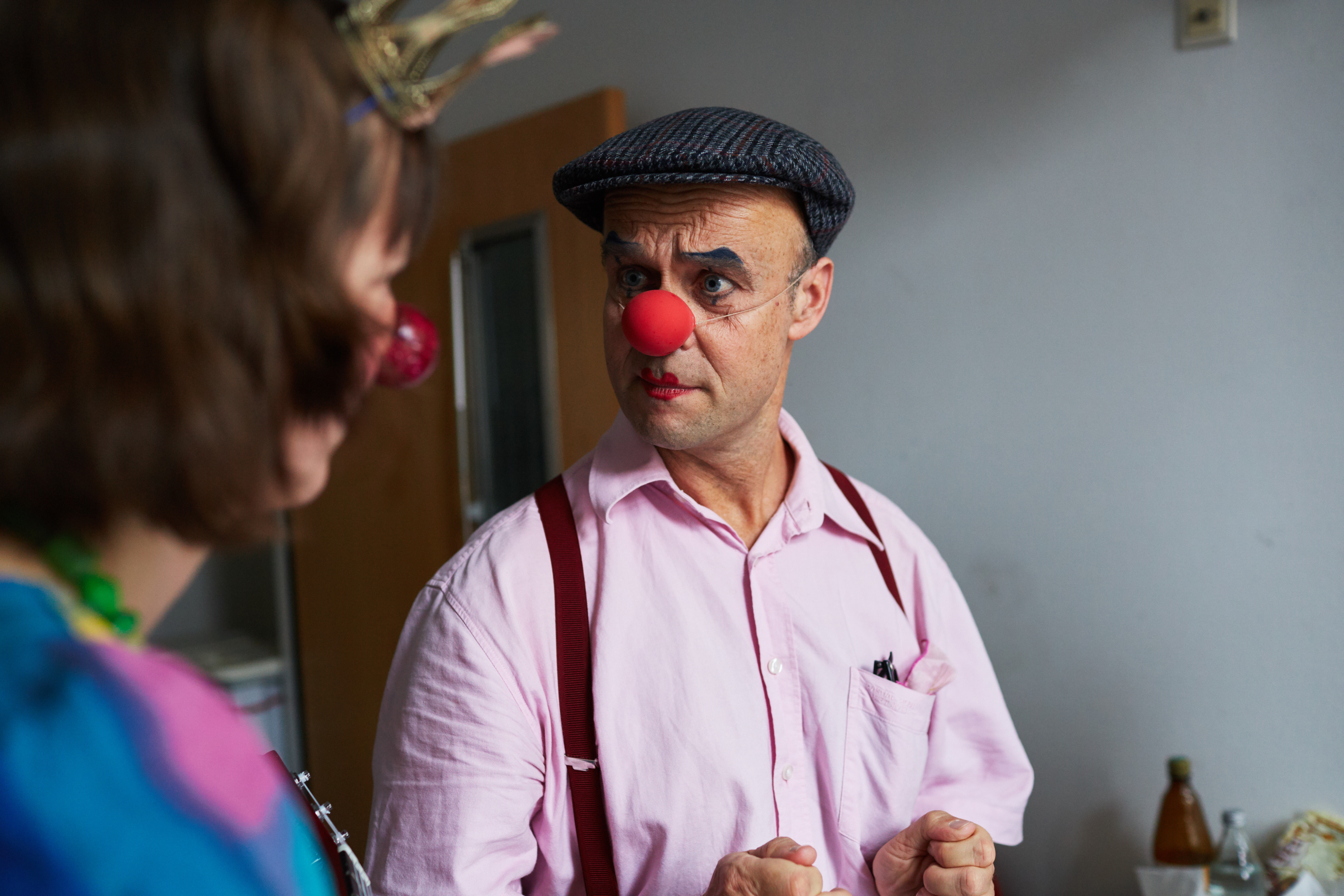 Clown Stefanello schaut Clown Emma fragend an. 